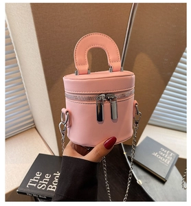 Close-up of pink cylinder bucket bag with double zip design and silver chain strap