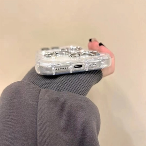 Close-up of precise speaker and charging port cutouts on glitter phone case with pearls