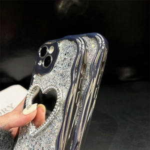 Detailed view of silver glitter phone case with heart mirror and rhinestone decoration