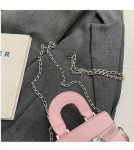 Detailed shot of pink bucket bag with silver metal chain and smooth leather texture