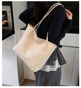 Gros plan du sac cabas beige en cuir grainé avec détails métalliques argentés élégants