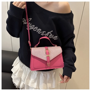 Detailed view of pink crossbody bag with sparkling rhinestones worn by a model
