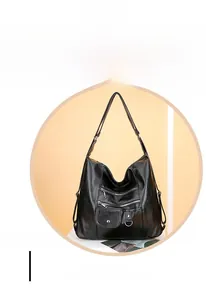 Detail view of the black soft leather handbag showing multiple zippers and silver hardware