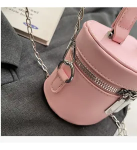 Detail of silver metal zipper and hardware on the pink leather bucket bag with chain strap