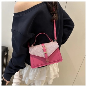 Detail of pink sequin crossbody bag with gold buckle on a model wearing white skirt