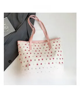 Detail view of large white tote bag with pink straps and cute bear cartoon patterns