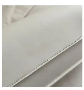 Detailed close-up of white leather bag featuring gold embossed Fashion & Bags lettering