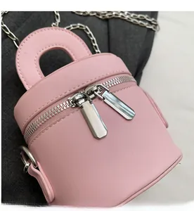Detailed macro view of smooth dual silver zippers on pink mini cylinder chain bag