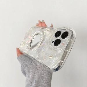 Détail de coque iPhone avec bords ondulés, mini miroir, roses blanches et papillons 3D