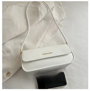 Size comparison of a white vintage underarm bag with a smartphone on fabric