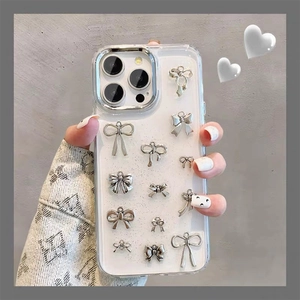 Dettaglio della custodia iPhone con fiocchi in metallo argento e glitter bianchi