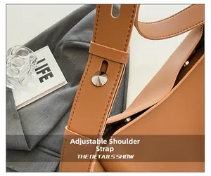Close-up of adjustable leather shoulder strap with silver metal studs and snap buttons