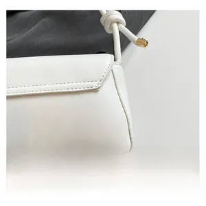 Detailed close-up of white leather texture and premium stitching on the elegant shoulder bag