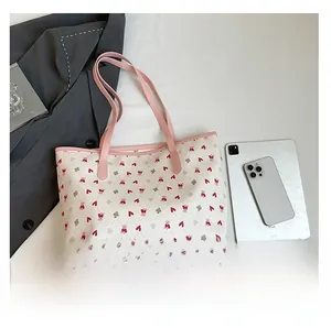 Detail view of large white tote bag with bear print and pink straps for daily commuting