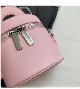 Detailed close-up of pink leather cylinder bag with silver dual zipper and top handle