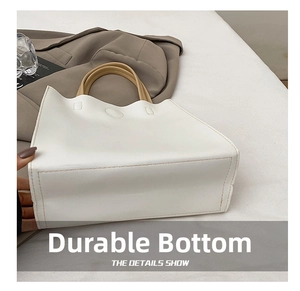 Close-up of durable wear-resistant bottom with neat stitching on white tote bag
