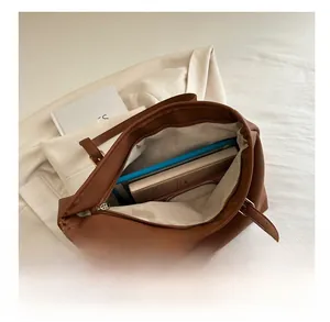 Interior view showing the large capacity of the brown PU leather tote bag and accessories