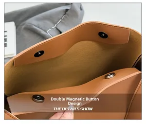 Close-up of the double magnetic snap closure on the brown faux leather tote bag