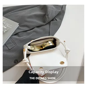 Internal capacity of the white PU leather bag showing phone and cosmetic storage