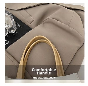 Detailed close-up of cream PU leather handbag with contrast brown handles and fine stitching
