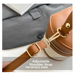 Detail of adjustable leather shoulder strap with gold metal buckle on a linen bucket bag