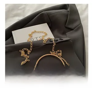 Macro view of golden metal chain strap and embroidered floral silk on vintage handbag