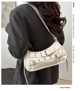 Detailed back view of a beige studded shoulder bag with vintage punk buckle straps