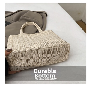 Detail of durable woven bottom on cream straw tote bag with fine braided texture