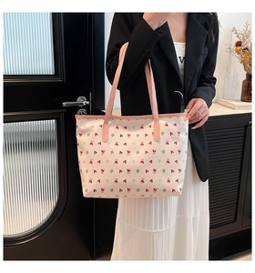 Close-up of heart and bear prints on the white leather tote bag with pink handles