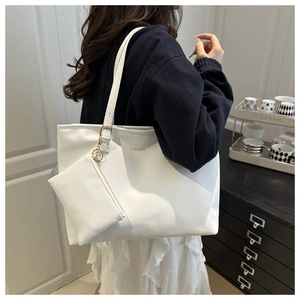 Detail of white cross-grain leather tote bag set with metal chain and fashion gold lettering