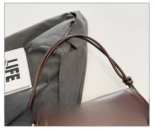 Detail showing the brown leather strap knot and YM & BAGS logo on a vintage flap bag