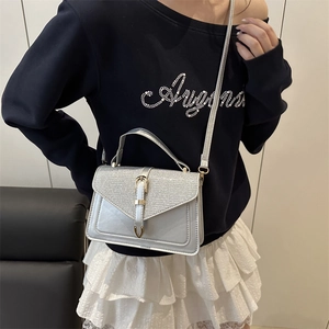 Silver sequined crossbody bag with gold heart lock and detachable shoulder strap