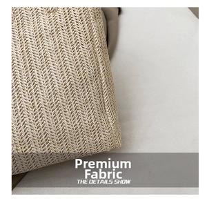 Close-up of hand-woven straw bag featuring intricate beige chevron pattern texture