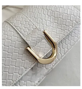Detail of white woven PU leather texture and premium gold U-shaped metal buckle on the bag