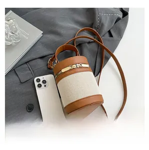Close-up of dual gold zippers on a vintage brown leather and beige woven bucket bag