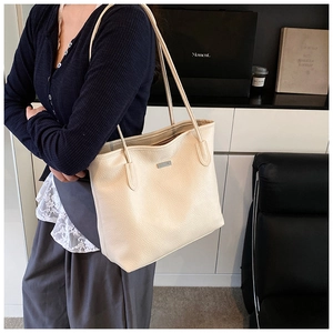 Dettaglio della borsa tote in pelle beige a grana con doppie spalline in stile moderno