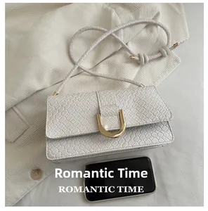 Detail of woven faux leather bag with gold U-buckle compared to a smartphone