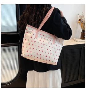 Detail of cute bear and heart print tote bag with pink leather trim and fine stitching