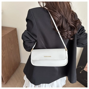 White leather shoulder bag with FASHION & BAGS text worn by a model in a home setting