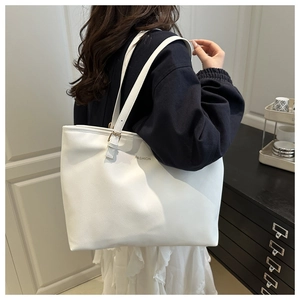 Détail d'un grand sac cabas blanc avec le logo Fashion et une boucle métallique