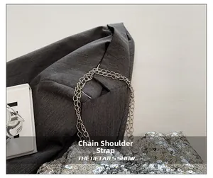 Close-up of sparkling silver sequins and delicate metal chain strap on fashion handbag