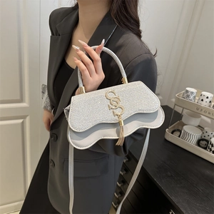 Petit sac carré à paillettes argentées avec logo S doré et détails de pompons sur cuir gris