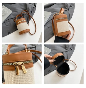 Detail view of contrast stitching cylinder bag showing golden zippers and interior capacity