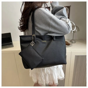 Détail d'un ensemble cabas noir et pochette zippée dans un cadre de bureau