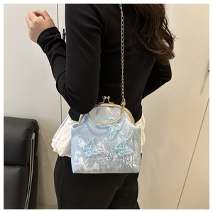 Detail of light blue jacquard shell bag featuring 3D butterfly embroidery and gold chain