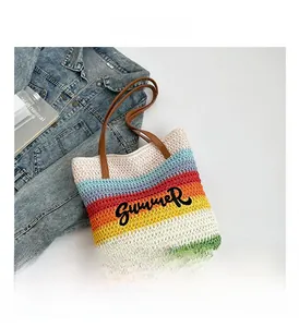 Detail of colorful striped woven bucket bag with Summer embroidery and leather handles