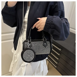 Detail of black rhinestone cylinder bag with metallic chain and small coin purse charm