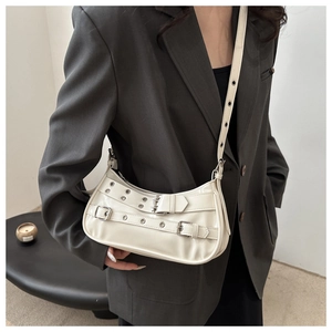 Detail of ivory glossy leather bag with metal grommet straps and vintage moto buckle