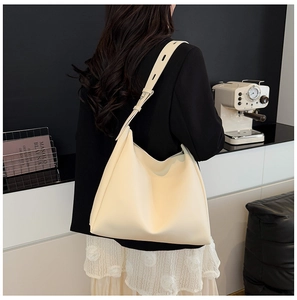 Close-up of the adjustable wide leather strap and metal buckle on the off-white hobo bag