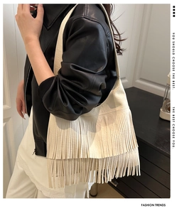 Detailed side view of white fringe hobo bag in a stylish bohemian fashion context